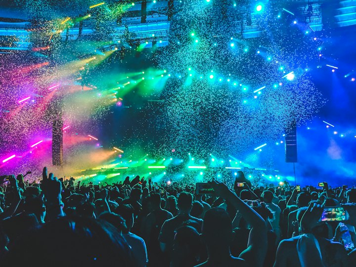 A crowd under green and blue stage lights